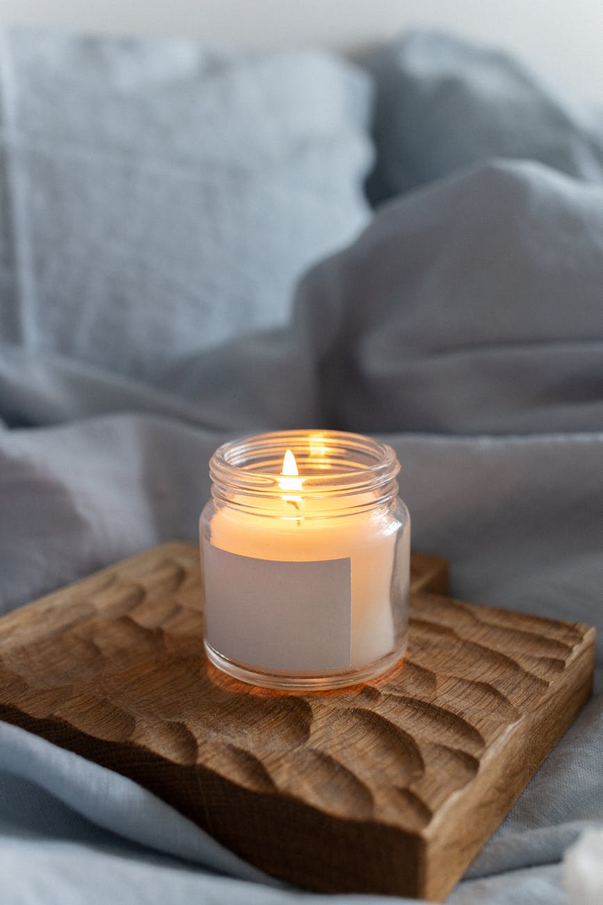 white candle in clear glass holder