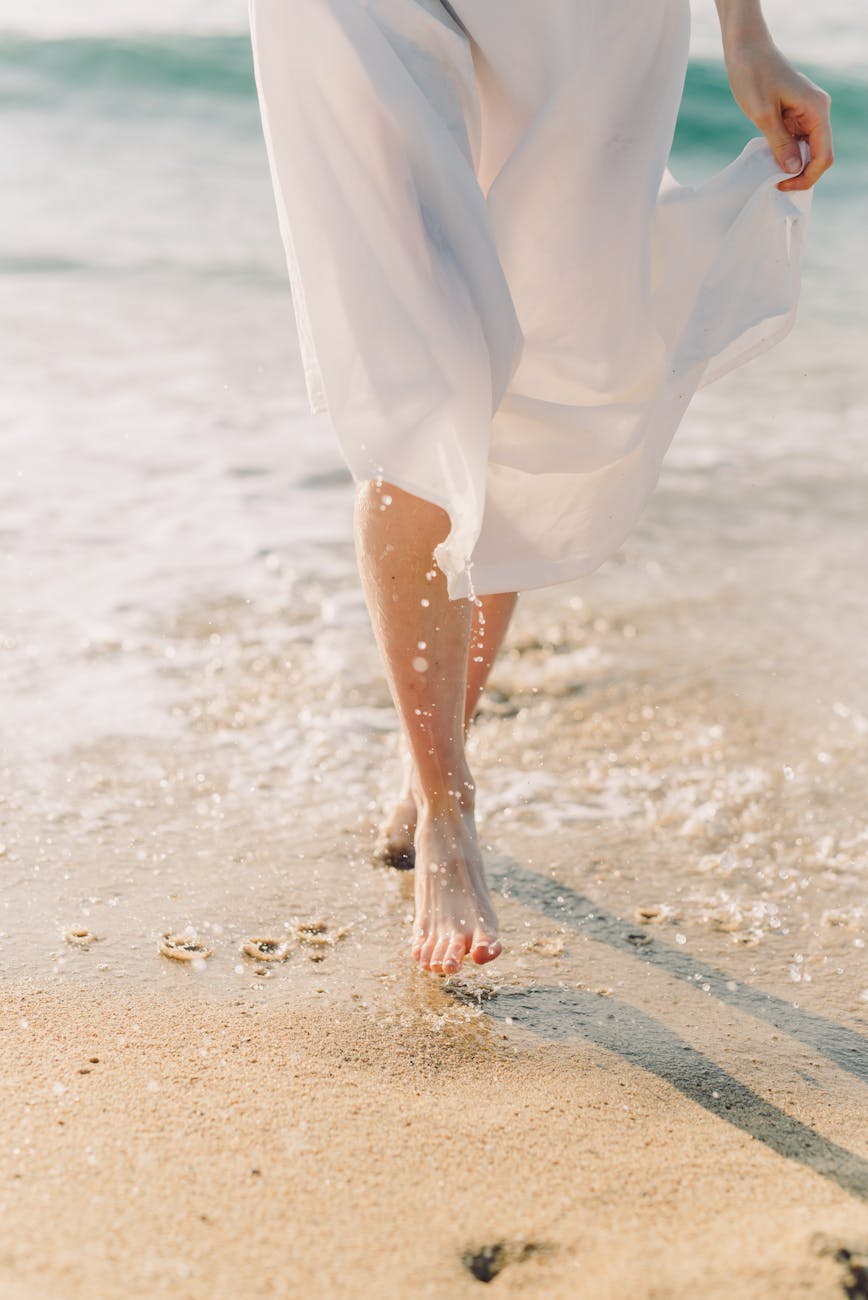 female barefoot walking on beach
